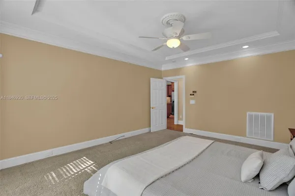 a spacious bedroom with a large bed and a chandelier