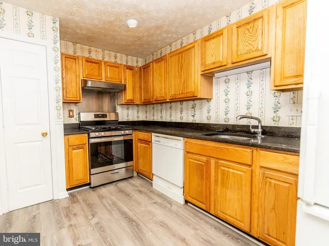 a kitchen with stainless steel appliances a stove a sink and a microwave