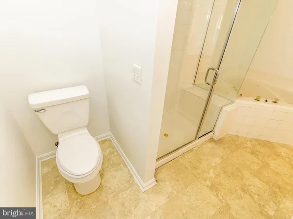 a white toilet sitting next to a shower