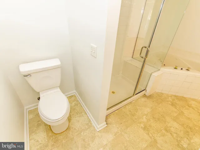 a white toilet sitting next to a shower