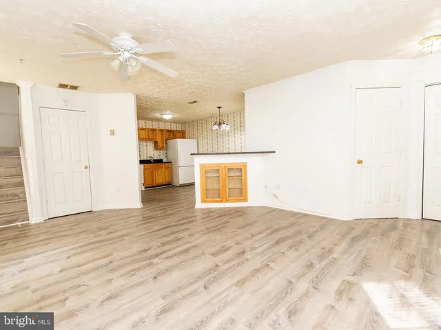 a view of an empty room with a kitchen