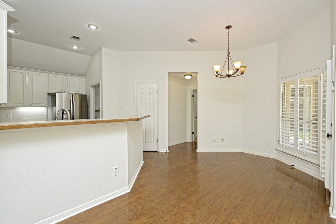 10917 Ballybunion Place Austin, TX 78747 - Photo 12 of 28 a view of a kitchen with kitchen island a refrigerator wooden floor and a sink