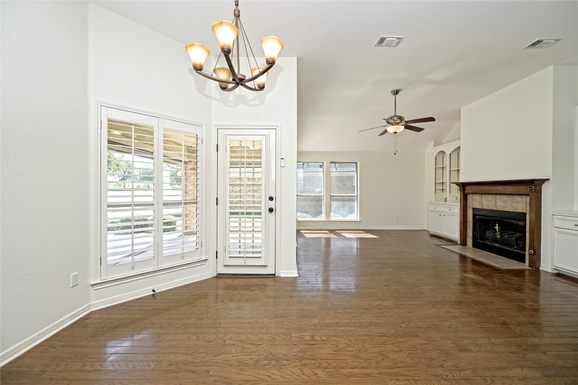 10917 Ballybunion Place Austin, TX 78747 - Photo 13 of 28 an empty room with windows fireplace and wooden floor