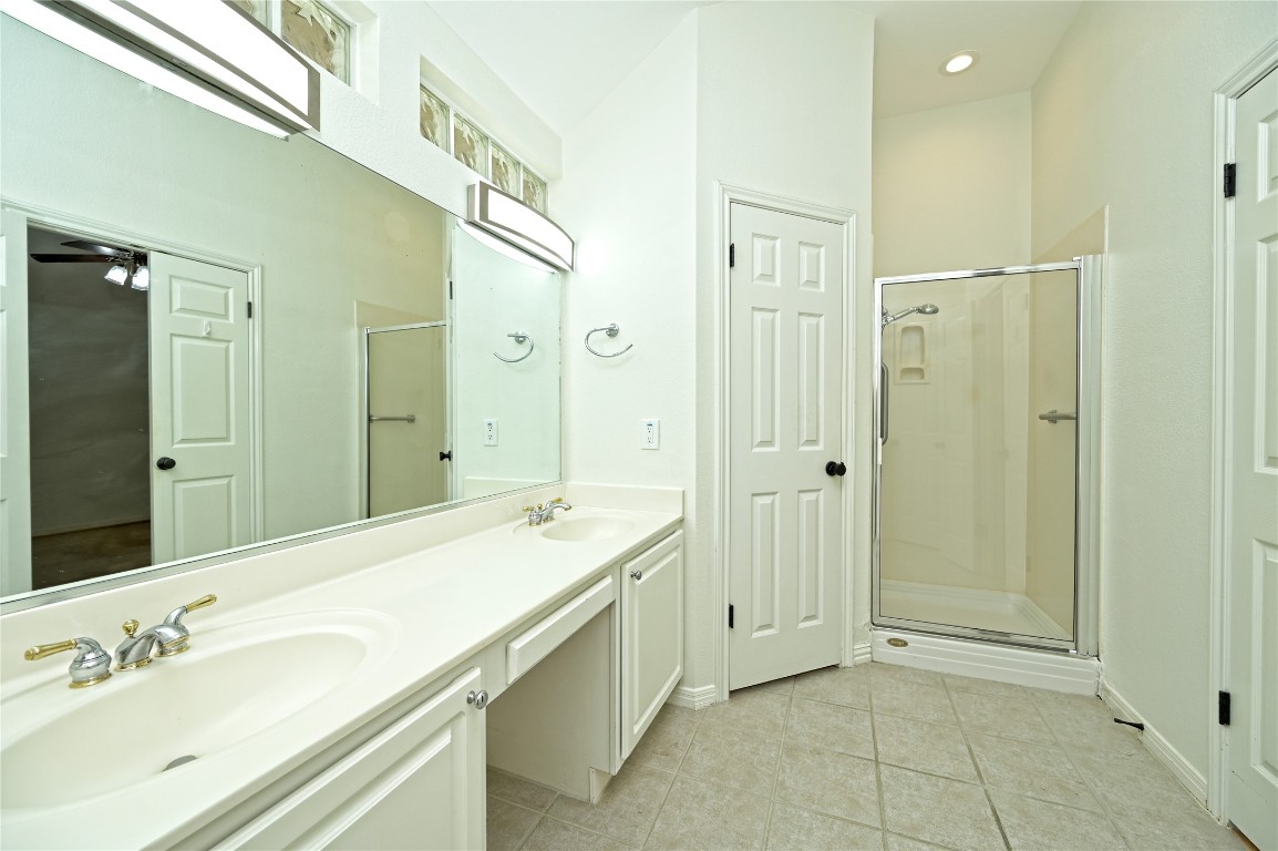 10917 Ballybunion Place Austin, TX 78747 - Photo 18 of 28 a spacious bathroom with a shower sink and mirror