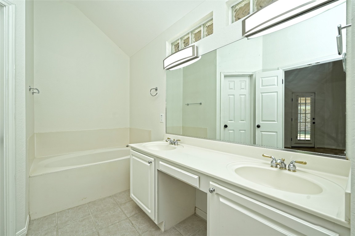 10917 Ballybunion Place Austin, TX 78747 - Photo 19 of 28 a bathroom with a sink a shower and a mirror