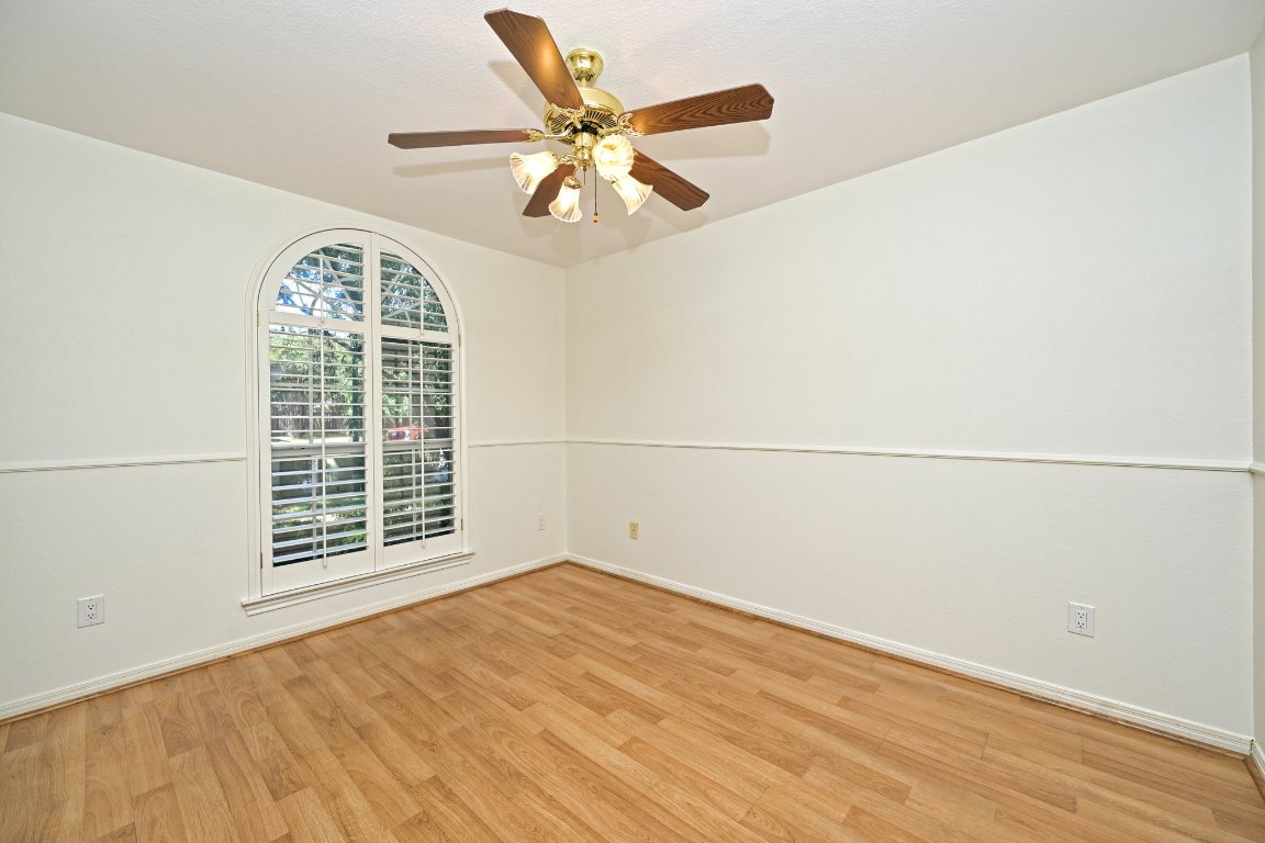 10917 Ballybunion Place Austin, TX 78747 - Photo 2 of 28 an empty room with wooden floor fan and windows