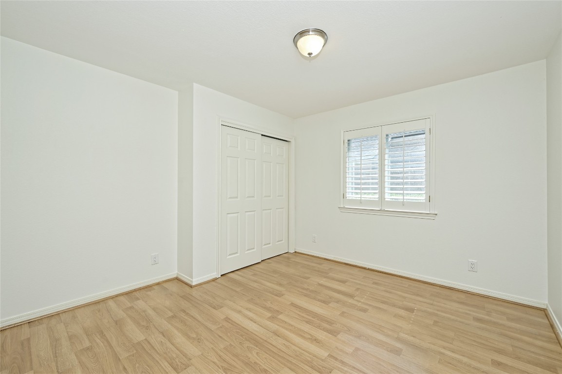10917 Ballybunion Place Austin, TX 78747 - Photo 22 of 28 an empty room with wooden floor and windows