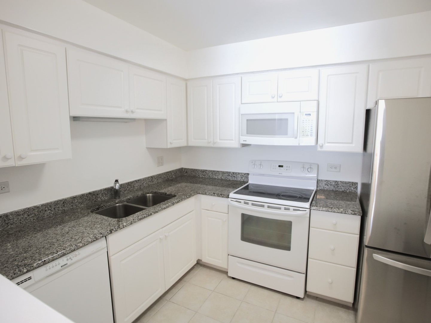 1400 North Elmhurst Road, Unit 417 Mount Prospect, IL 60056 - Photo 10 of 15 a kitchen with white cabinets and white appliances