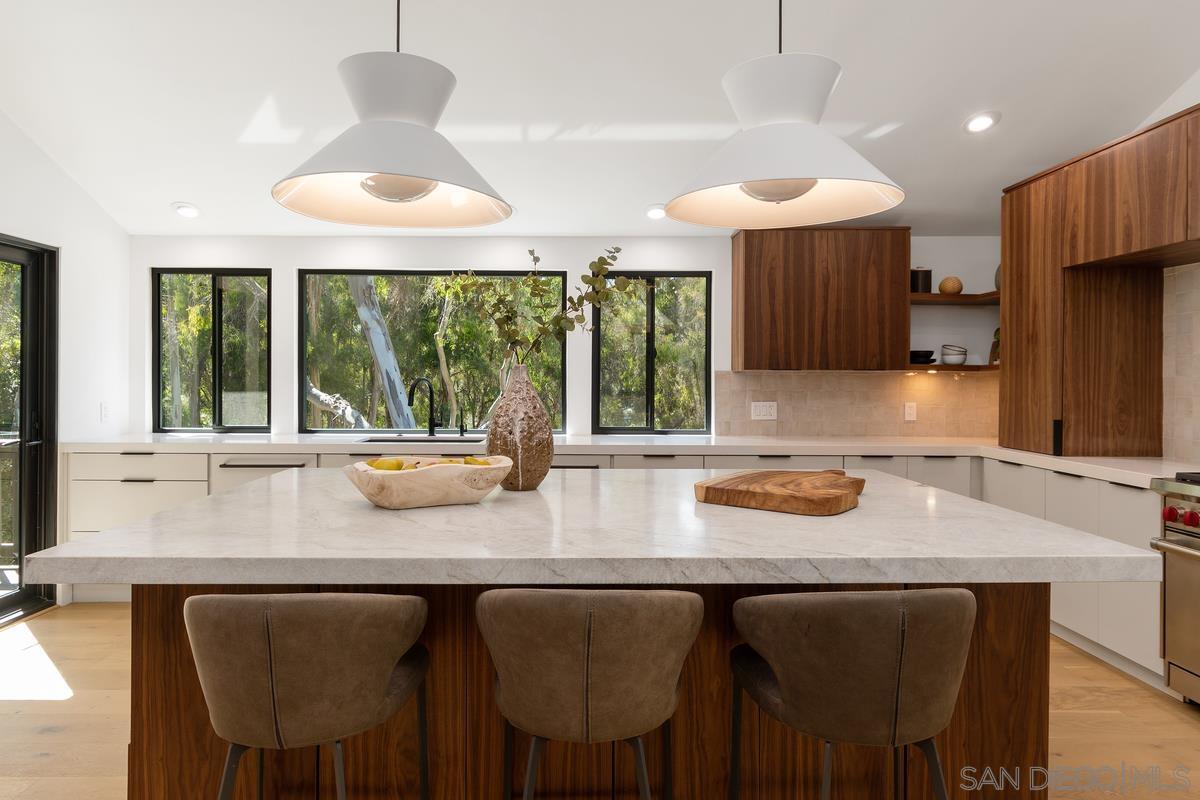 a kitchen with stainless steel appliances granite countertop a sink and a large window