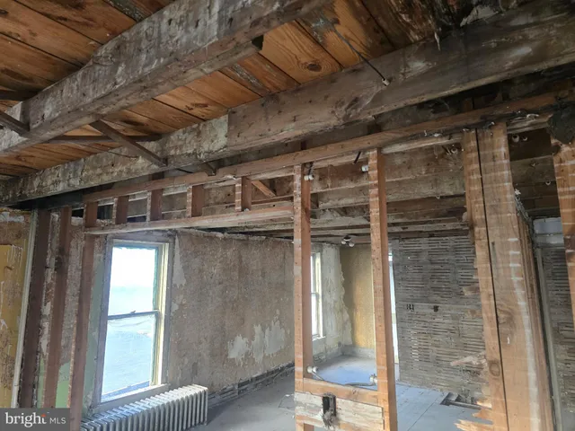 a view of an empty room with wooden floor and a fireplace