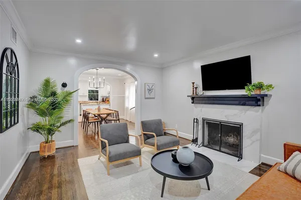 a living room with furniture a fireplace and a flat screen tv
