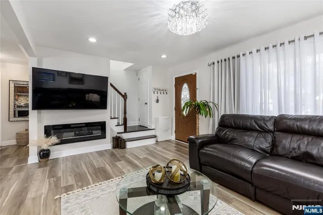 a living room with furniture a flat screen tv and kitchen view