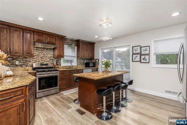 a kitchen with granite countertop stainless steel appliances a sink and counter space