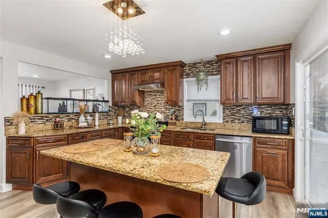 a kitchen with kitchen island granite countertop a sink and cabinets