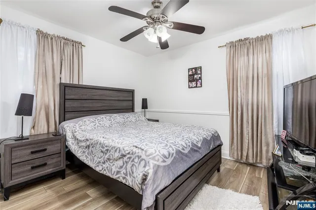 a bedroom with a bed and a flat tv screen on a dresser