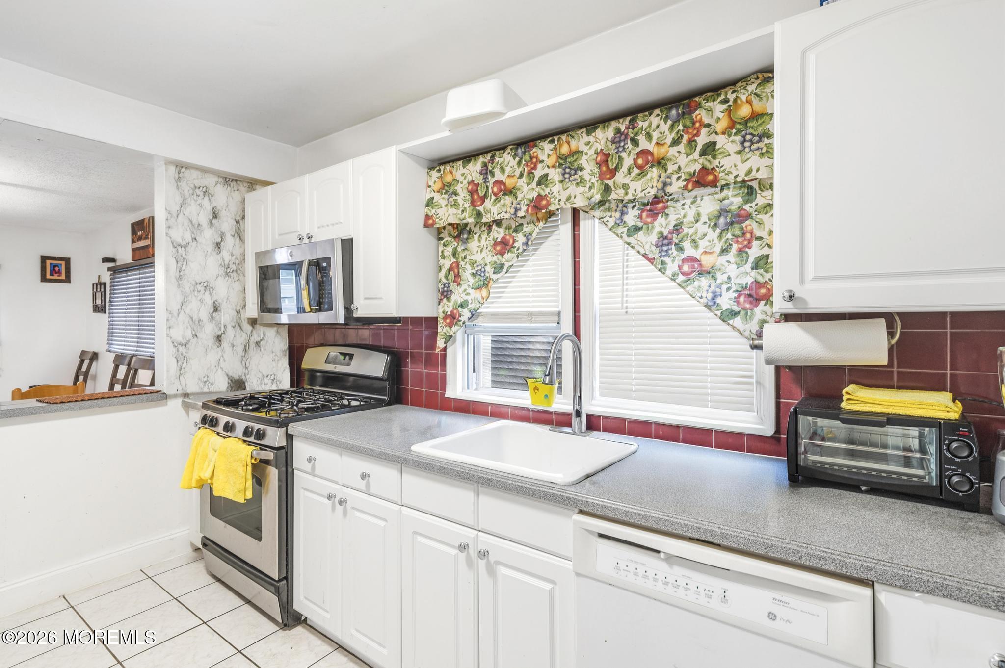 1914 Rutherford Avenue Neptune Township, NJ 07753 - Photo 15 of 25 a kitchen with a stove a sink and a microwave