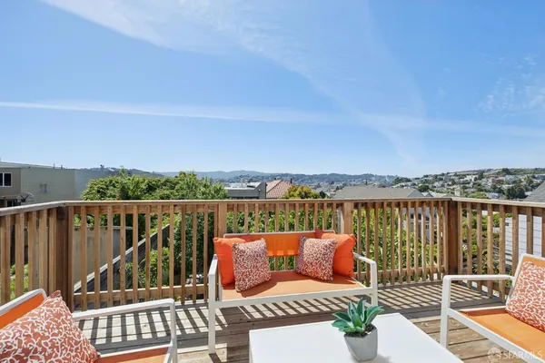 a balcony with wooden floor and city view