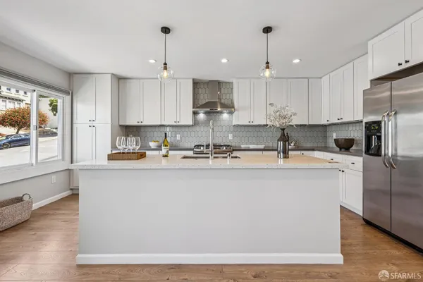 a kitchen with stainless steel appliances granite countertop a sink a stove a refrigerator a center island and cabinets