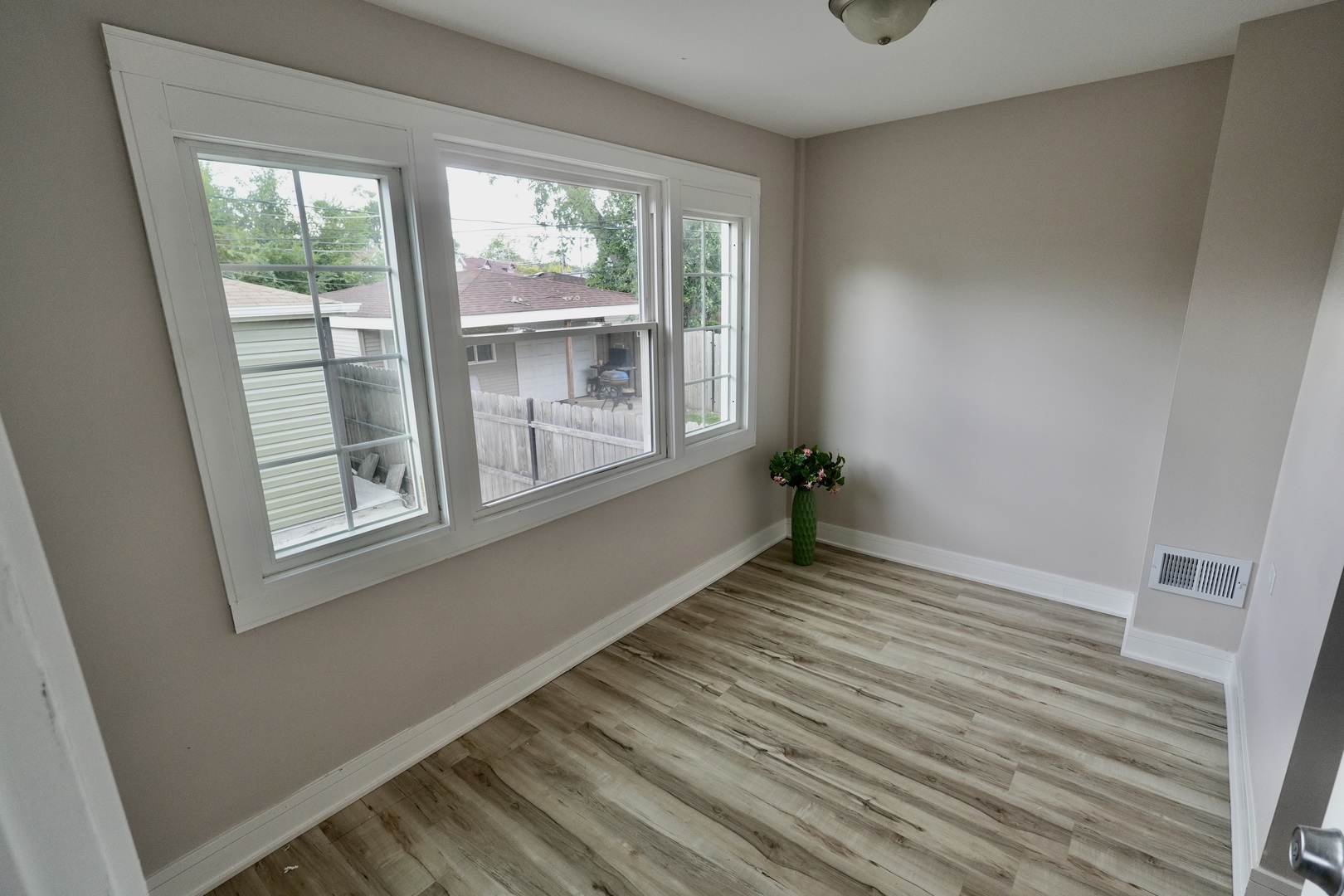 8734 South Honore Street Chicago, IL 60620 - Photo 13 of 33 a view of an empty room with wooden floor and a window