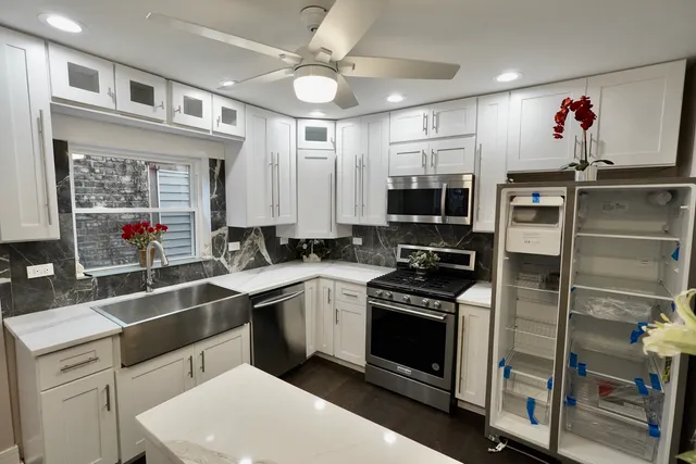a kitchen with a sink stainless steel appliances and white cabinets