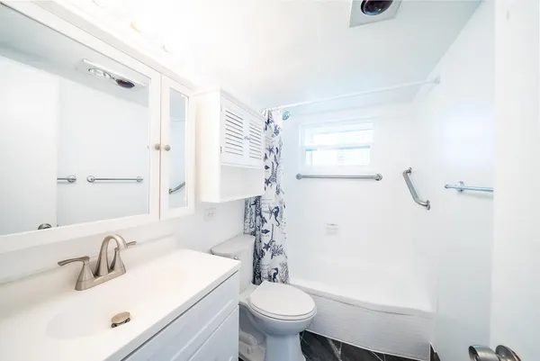 a bathroom with a sink a toilet and shower