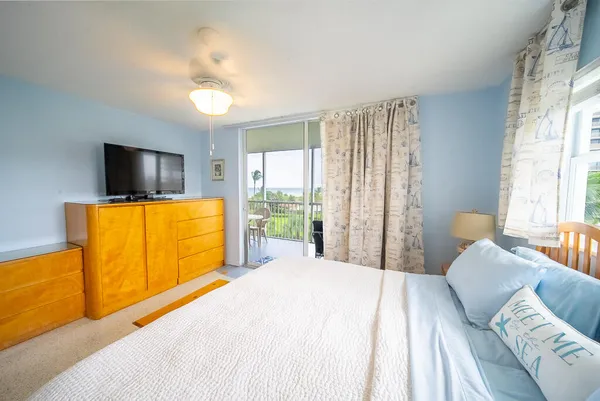 a bedroom with a bed and large windows