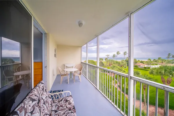a balcony with chairs and city view