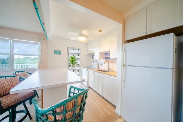 a kitchen with stainless steel appliances a refrigerator a stove a sink a dining table and chairs
