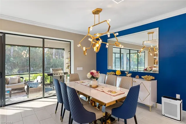 a dining room with furniture a chandelier and window