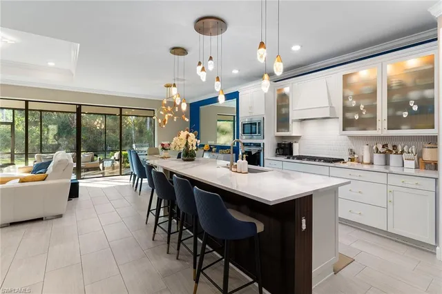 a kitchen with a sink a counter top space and living room view