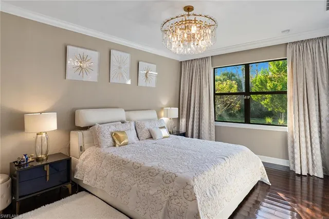 a bedroom with a large bed and a chandelier
