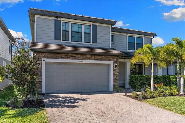 a front view of a house with plants
