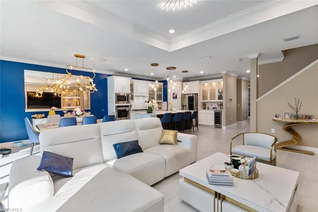 a living room with furniture kitchen view and a large window