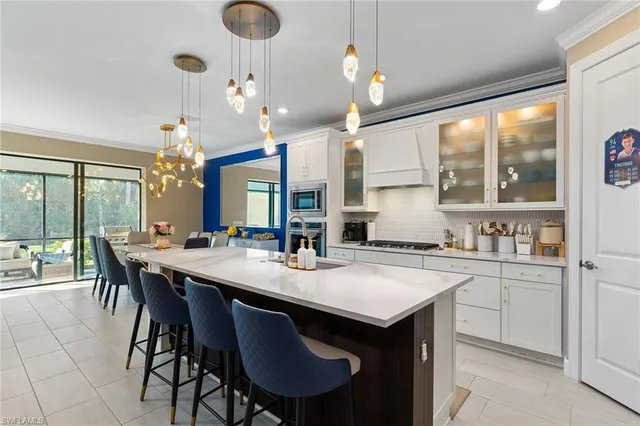 a kitchen with a dining table chairs sink and cabinets