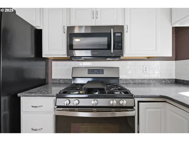 a kitchen with stainless steel appliances granite countertop a stove and a microwave