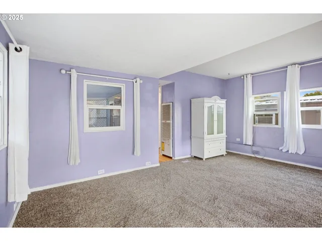 a view of empty room with wooden floor and cabinet