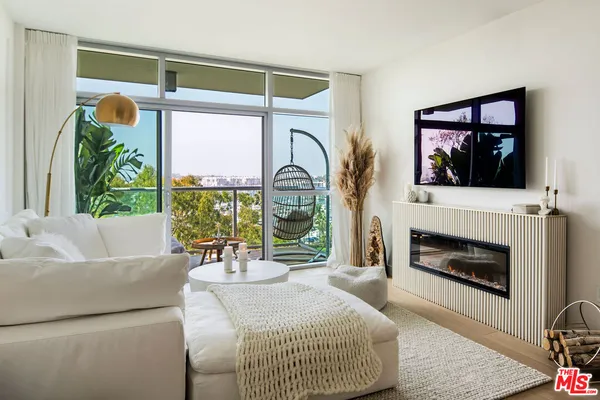 a living room with furniture and a floor to ceiling window