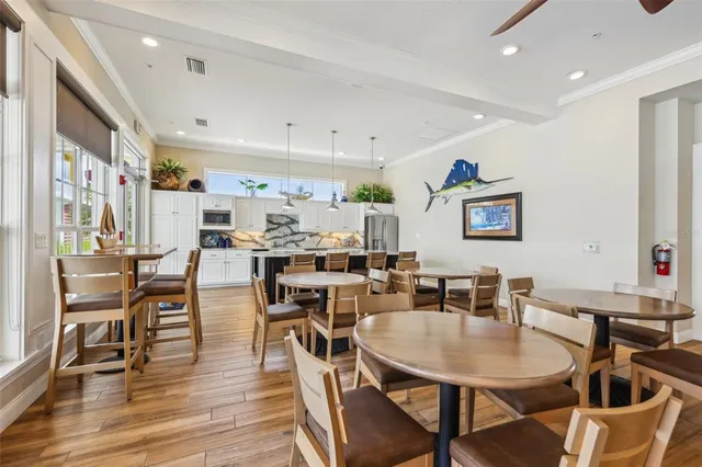 a dining room with stainless steel appliances kitchen island granite countertop a table chairs and a refrigerator