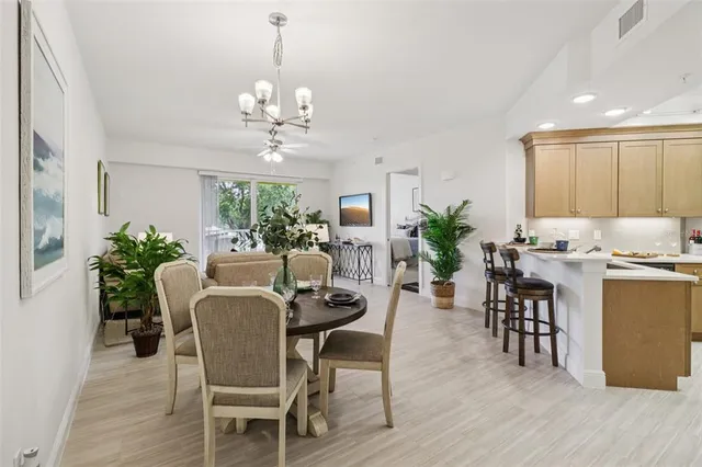 a dining room with furniture a chandelier and wooden floor