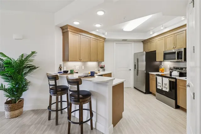 a kitchen with stainless steel appliances granite countertop a sink a stove and a refrigerator