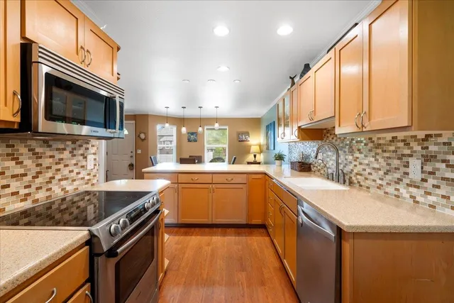 a kitchen with stainless steel appliances a stove a sink and a microwave
