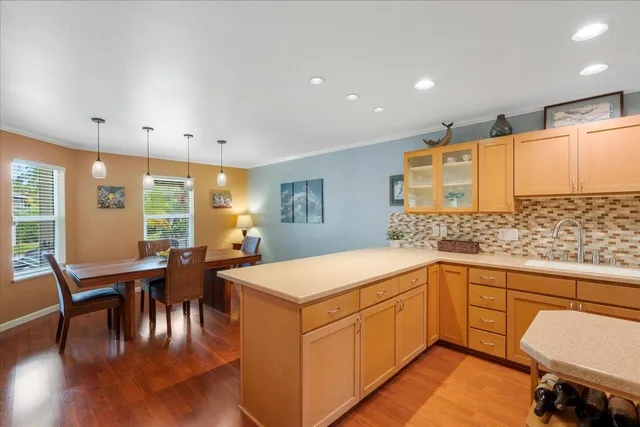 a view of a dining room and livingroom with furniture wooden floor a rug a fireplace and a chandelier