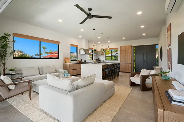 a living room with furniture kitchen view and a chandelier