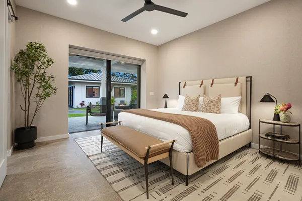 a spacious bedroom with a bed and a chandelier