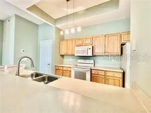 a kitchen with stainless steel appliances granite countertop a sink a stove and cabinets