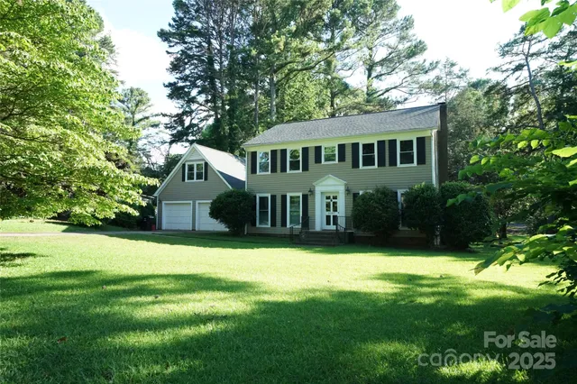 a front view of a house with yard and green space