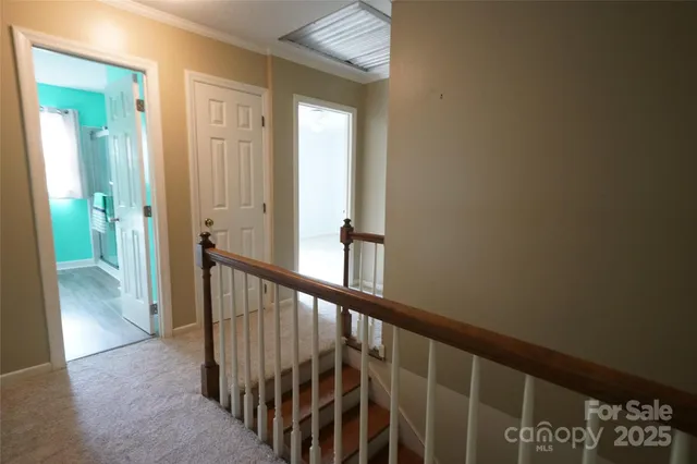 a view of a hallway with wooden floor and stairs