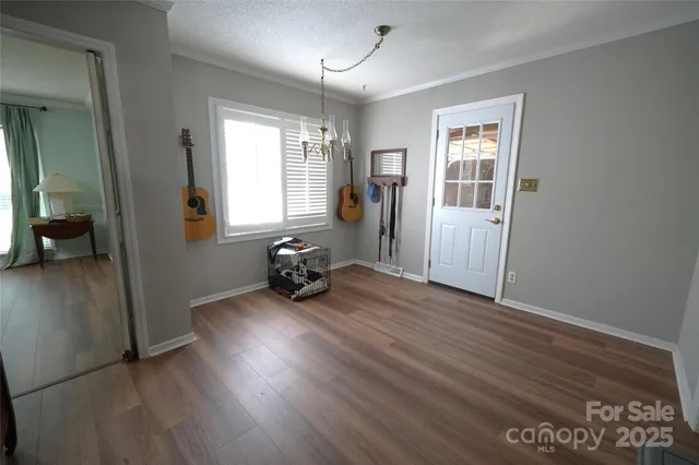 a view of a room with wooden floor and furniture