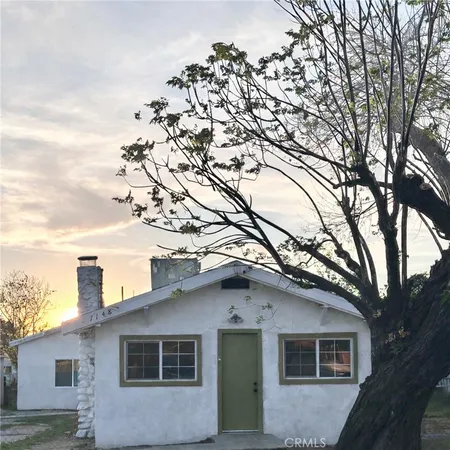 a house that has a tree in front of it