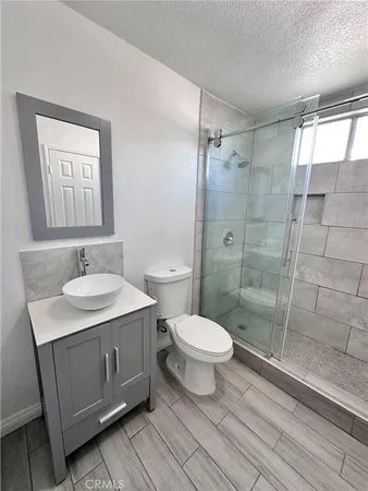 a bathroom with a sink toilet a mirror and shower